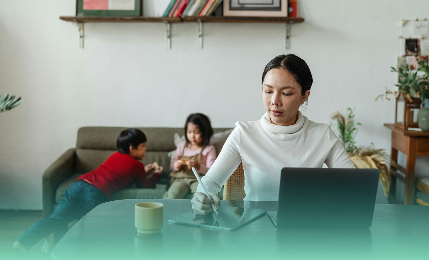 Woman working at computer while her kids play in the background